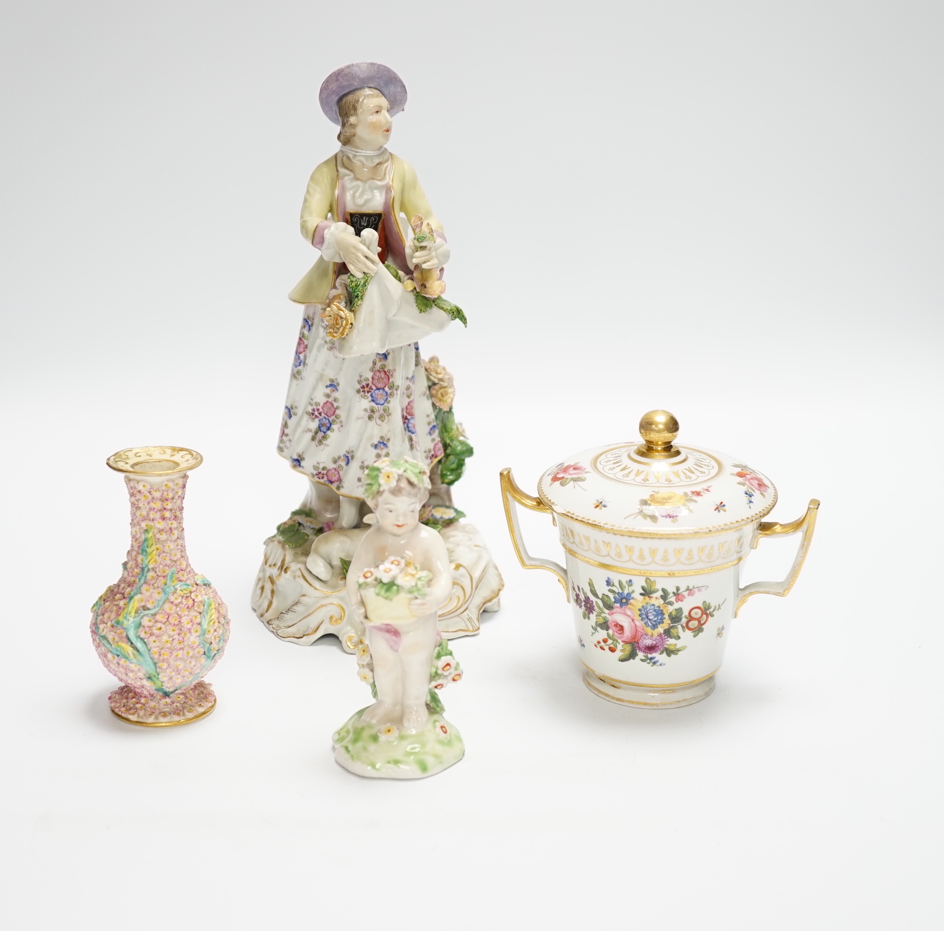 A late 19th century Continental porcelain figure of a lady, a Pinxton-type chocolate cup and cover, a Derby putti and a small Minton flower encrusted vase, figure 24.5cm (4)